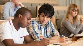 International students sitting over study materials in the lecture hall.